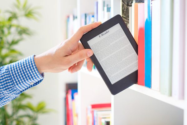 Hand pulling eBook reader off bookshelf