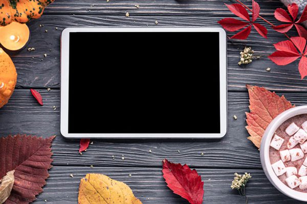 Tablet surrounded by leaves and hot cocoa, representing Thanksgiving videos in the Just for Kids Streaming Collection for public libraries
