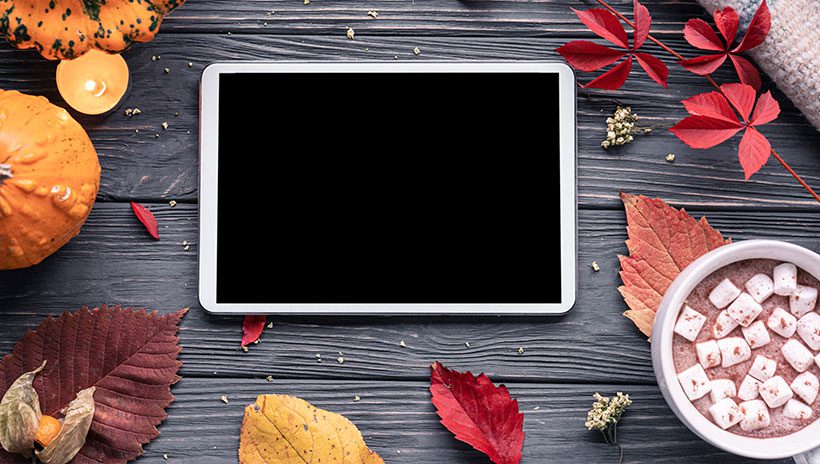 Tablet surrounded by leaves and hot cocoa, representing Thanksgiving videos in the Just for Kids Streaming Collection for public libraries