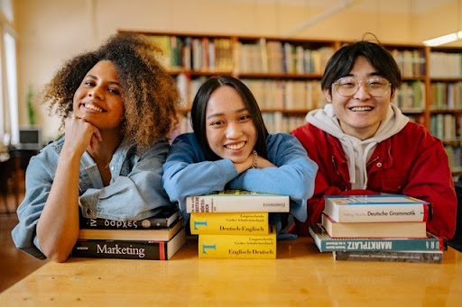 Three college students celebrating Black History Month at the library