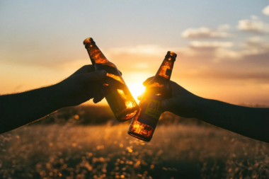 two friends toasting with beer bottles