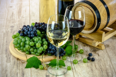 Two glasses of wine with grapes and small cask