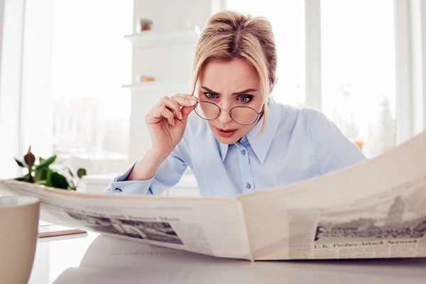 Woman evaluating and assessing an article in a newspaper