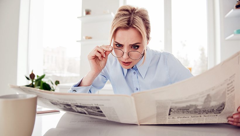Woman evaluating and assessing an article in a newspaper