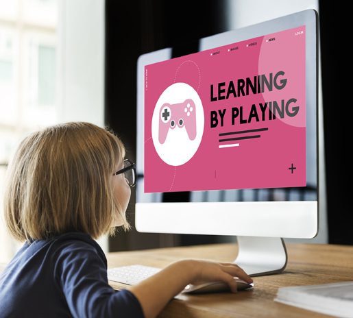 Young student playing educational game "Learning by Playing" at workstation