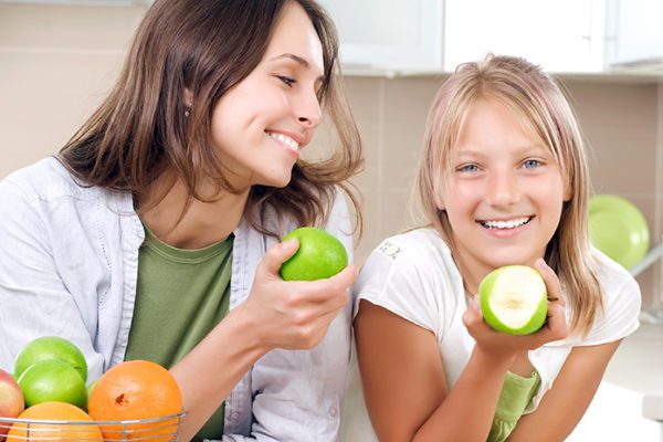 Teenager and her mother eating healthy food, as health and nutrition are an important consideration for teens' health