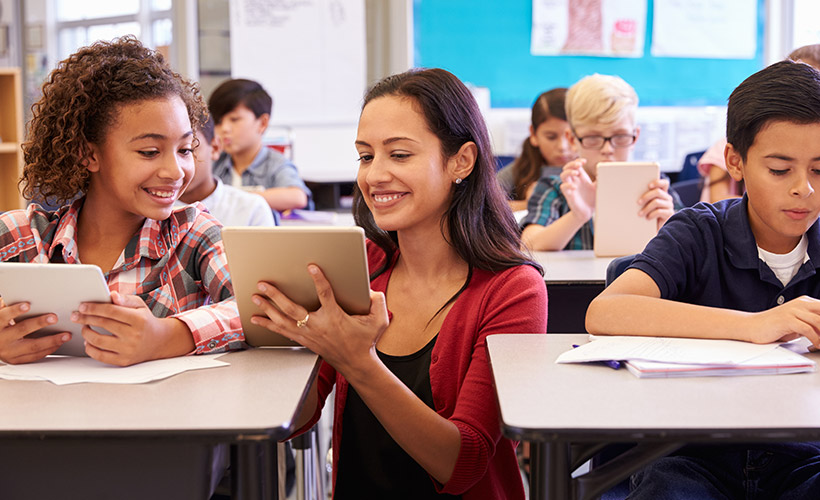 Teacher showing student a multimedia project on her tablet