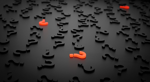 Table with pile of question marks, some of them glowing orange