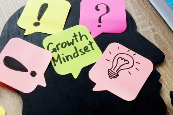 Man's silhouette with sticky notes, one with "Growth Mindset" written on it
