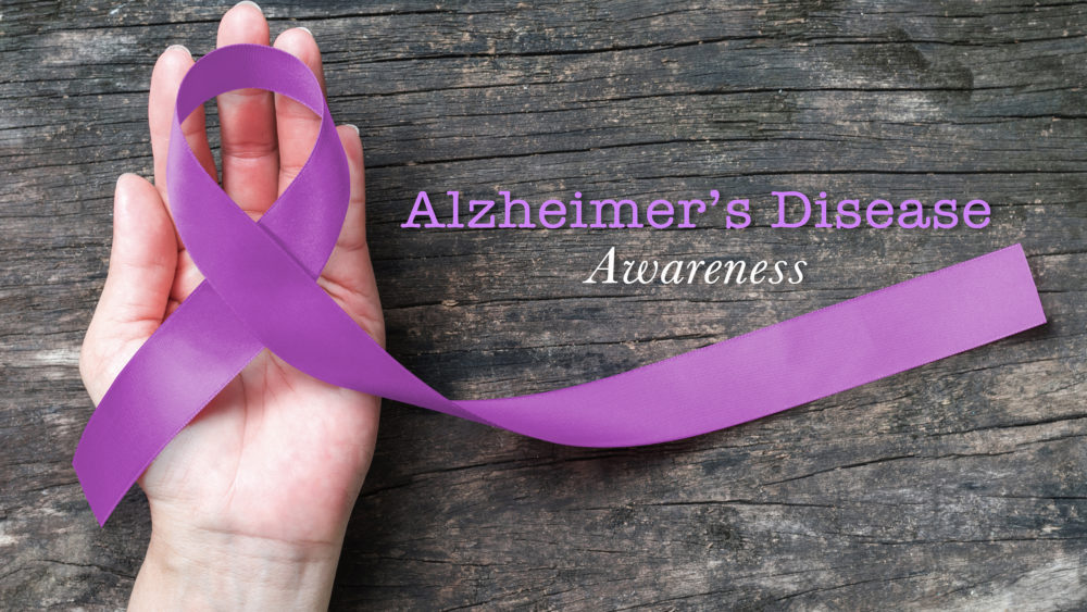 hand with purple ribbon for Alzheimer's disease awareness