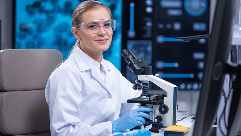 Female STEM researcher at a microscope
