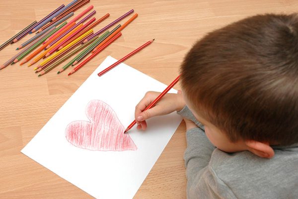 Little boy drawing a heart