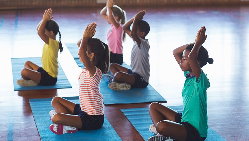 Children doing yoga, practicing breathing techniques