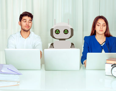 Young workers at laptops next to a robot, representing increasing automation