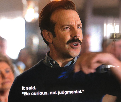 Ted Lasso saying, "Be curious, not judgmental."